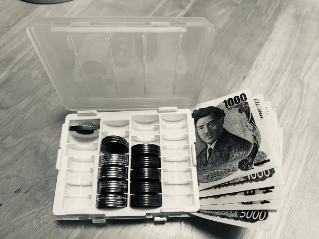 小銭とお札の入った釣り銭入れの画像